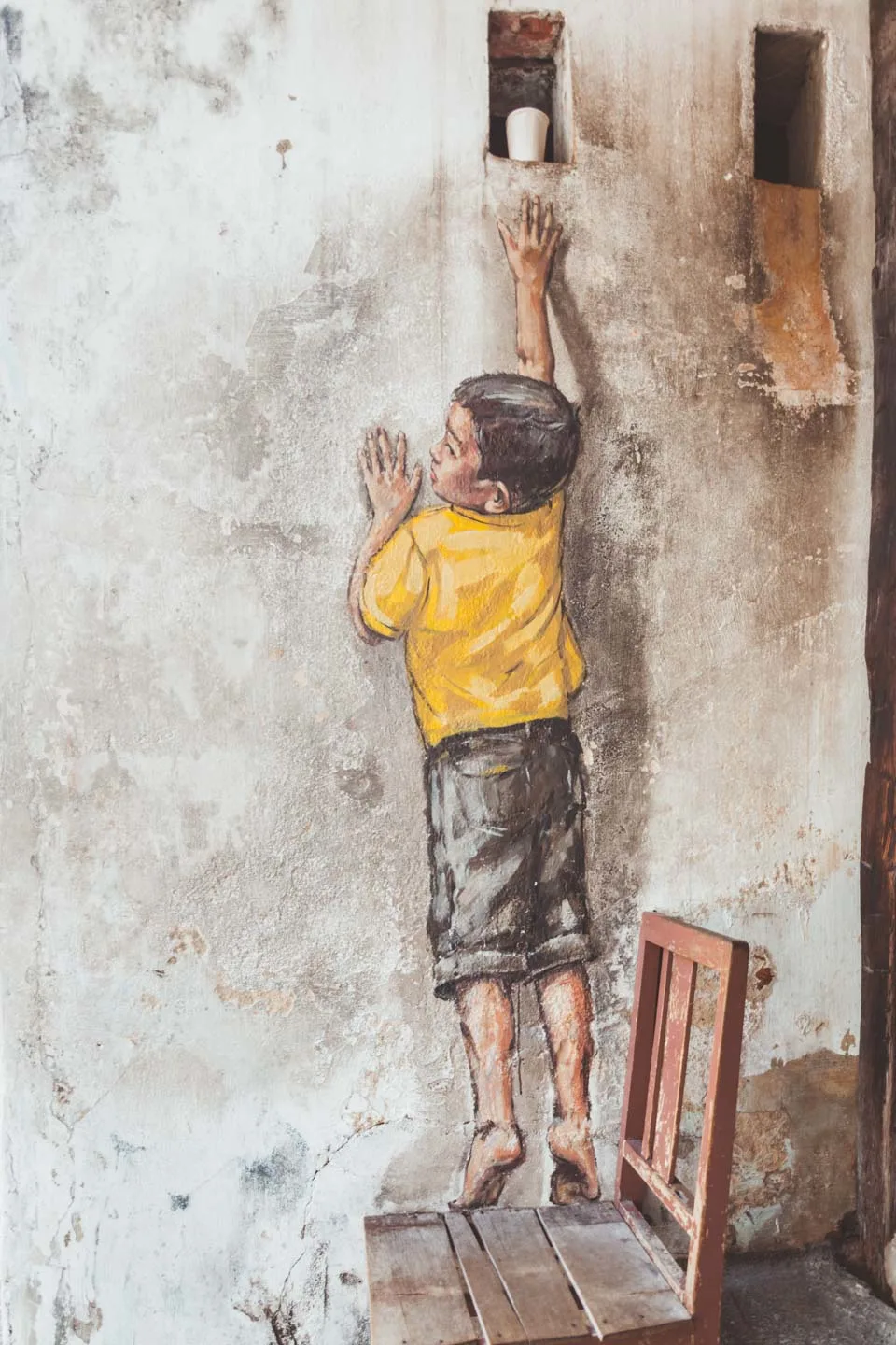 Ernest Zacharevic, Boy on Chair, Reaching Up, Penang Street Art, Malaysia