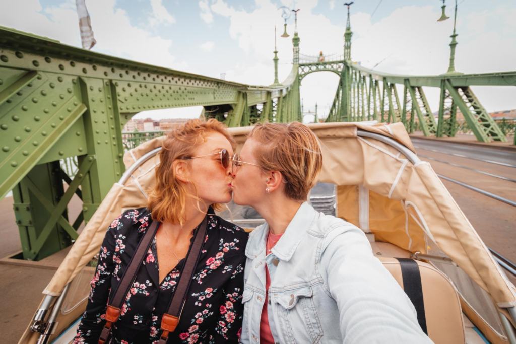 Gay couple kissing in a tuk tuk on the Liberty Bridge, Budapest, Hungary
