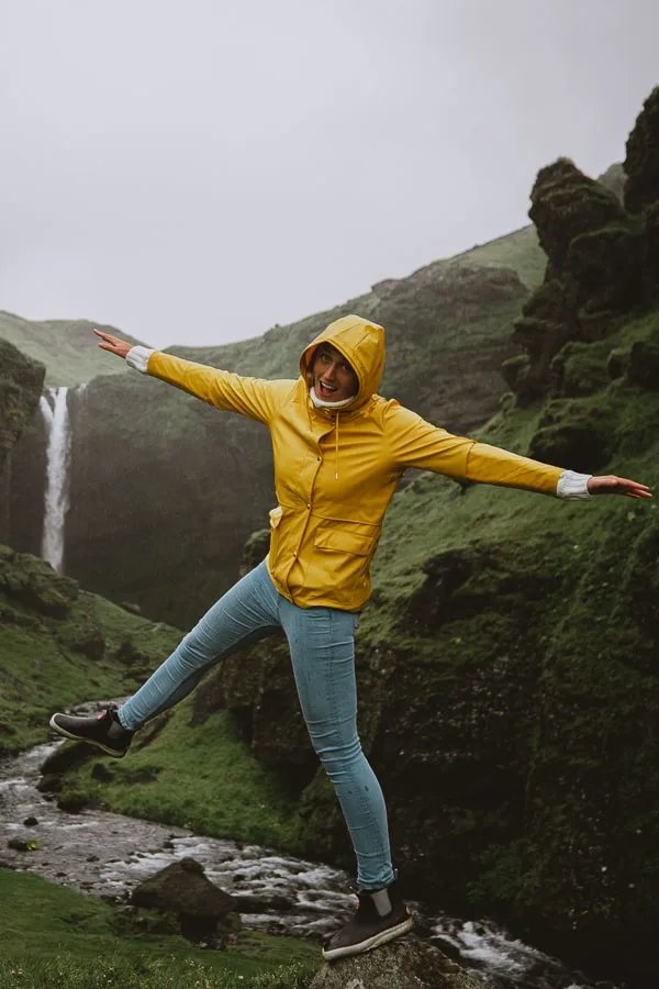 Girl in yellow rain coast best jacket for Iceland waterfall