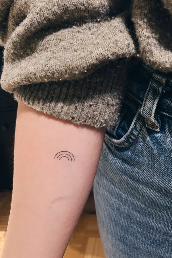 Minimalist Small Rainbow Tattoo on Arm Sarah by Slavena Vena
